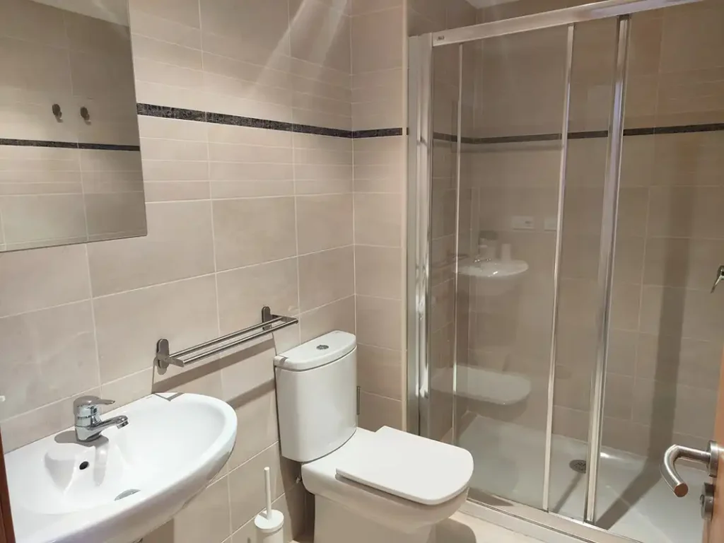 Baño con ducha de mampara de cristal, inodoro y lavabo en el apartamento Apartagal San Miguel de Barreiros