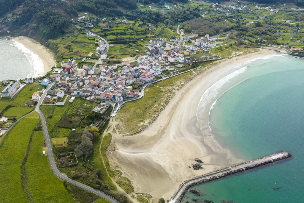 Vista aérea de Espasante con su playa en forma de concha y el espigón del puerto
