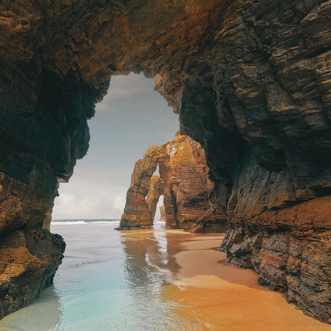 Arcos de la Playa de las Catedrales con marea baja en un día tranquilo de temporada media