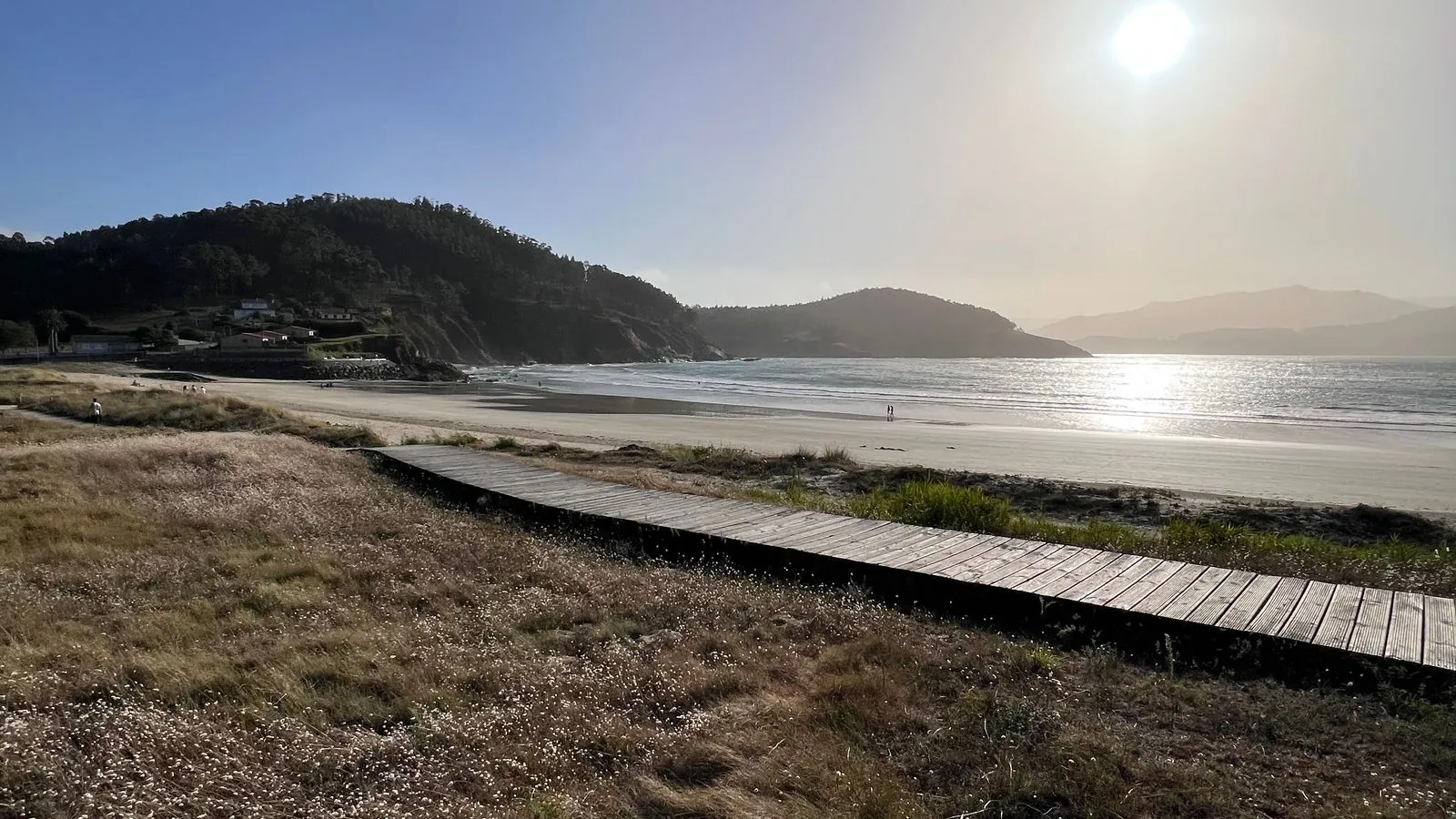 Playa de Espasante con la pasarela de madera sobre la duna y los montes de la ría al fondo
